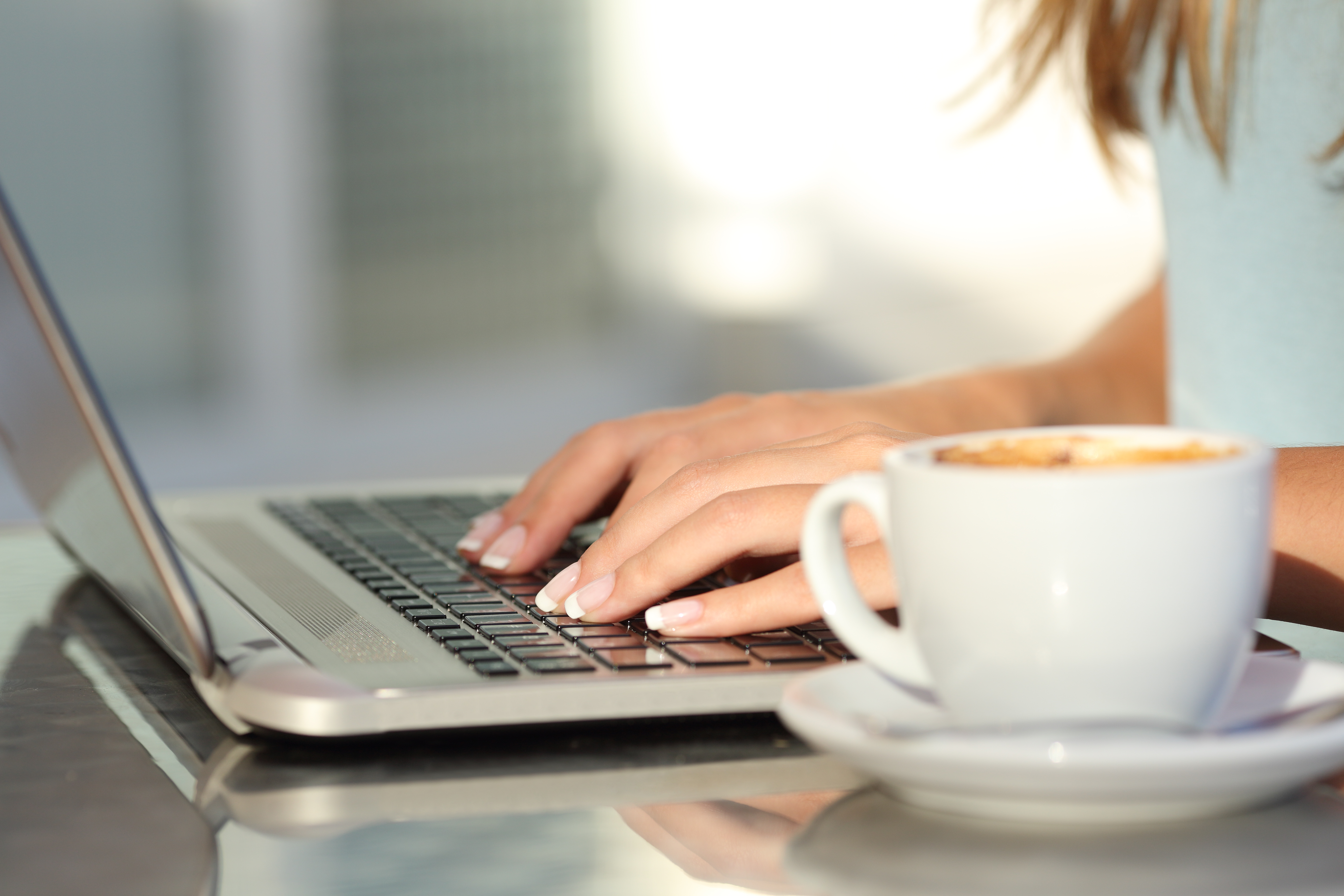 Woman Typing Next To Coffee
